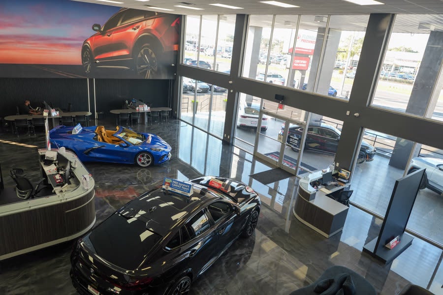 Florida Preowned indoor showroom at 3450 W Colonial Drive, Orlando, FL 32808 — pre-owned luxury and sport vehicles displayed on the polished showroom floor.