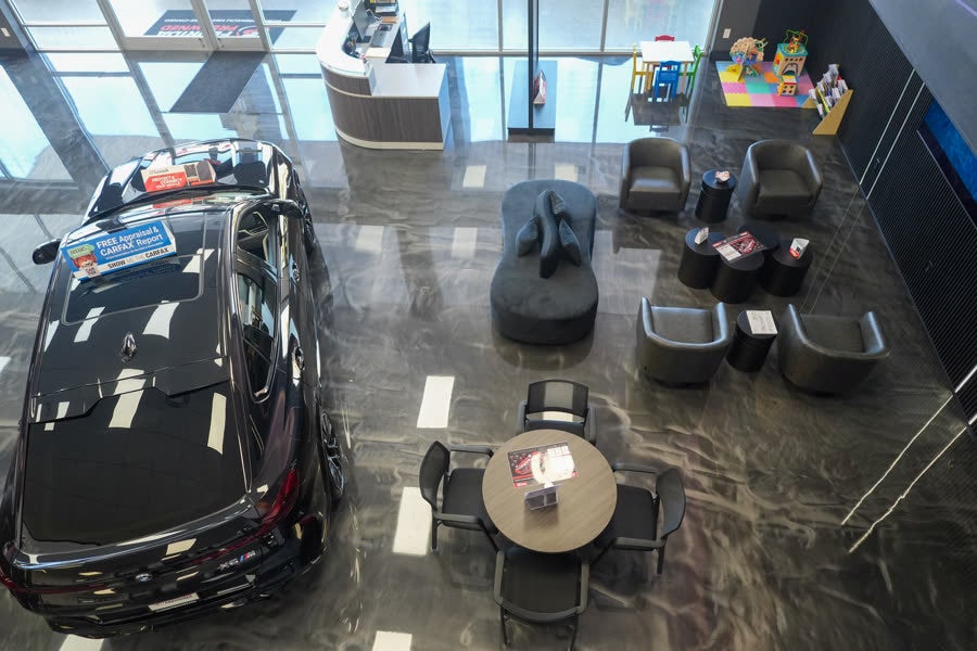 Florida Preowned customer lounge at 3450 W Colonial Drive, Orlando, FL 32808 — family-friendly waiting area with seating, beverage station, and a kids' play corner alongside a featured pre-owned SUV.