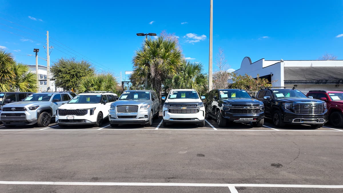 Florida Preowned premium SUV inventory at 3450 W Colonial Drive, Orlando, FL 32808 — pre-owned Lincoln Navigator, GMC Yukon Denali, Chevrolet Tahoe, and Toyota 4Runner lined up under blue Florida sky, popular among Lake Nona Medical City professionals.